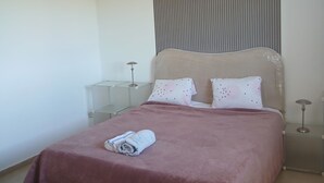 A bedroom with a bed, a bedside table, a lamp, and a hanging light fixture. - A lovely, beautiful view (Nefza)