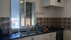 A modern kitchen with a large window, white cabinetry, and a black countertop. - A lovely, beautiful view (Nefza)
