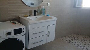 A bathroom with a washing machine, a sink with a mirror, and a window. - A lovely, beautiful view (Nefza)