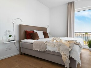 Een moderne slaapkamer met een bed, nachtkastje en uitzicht op de omgeving.