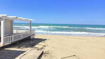 Una playa con una estructura de madera, posiblemente una estación de salvavidas, y el océano al fondo.