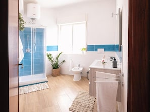 A modern bathroom with a shower, toilet, and sink. - Appartamenti Abate Limoncello (Alcamo)