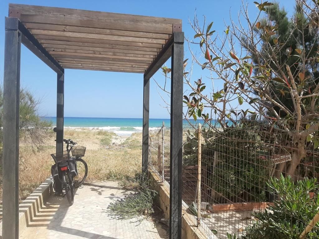 A wooden pergola structure with a bicycle parked underneath.