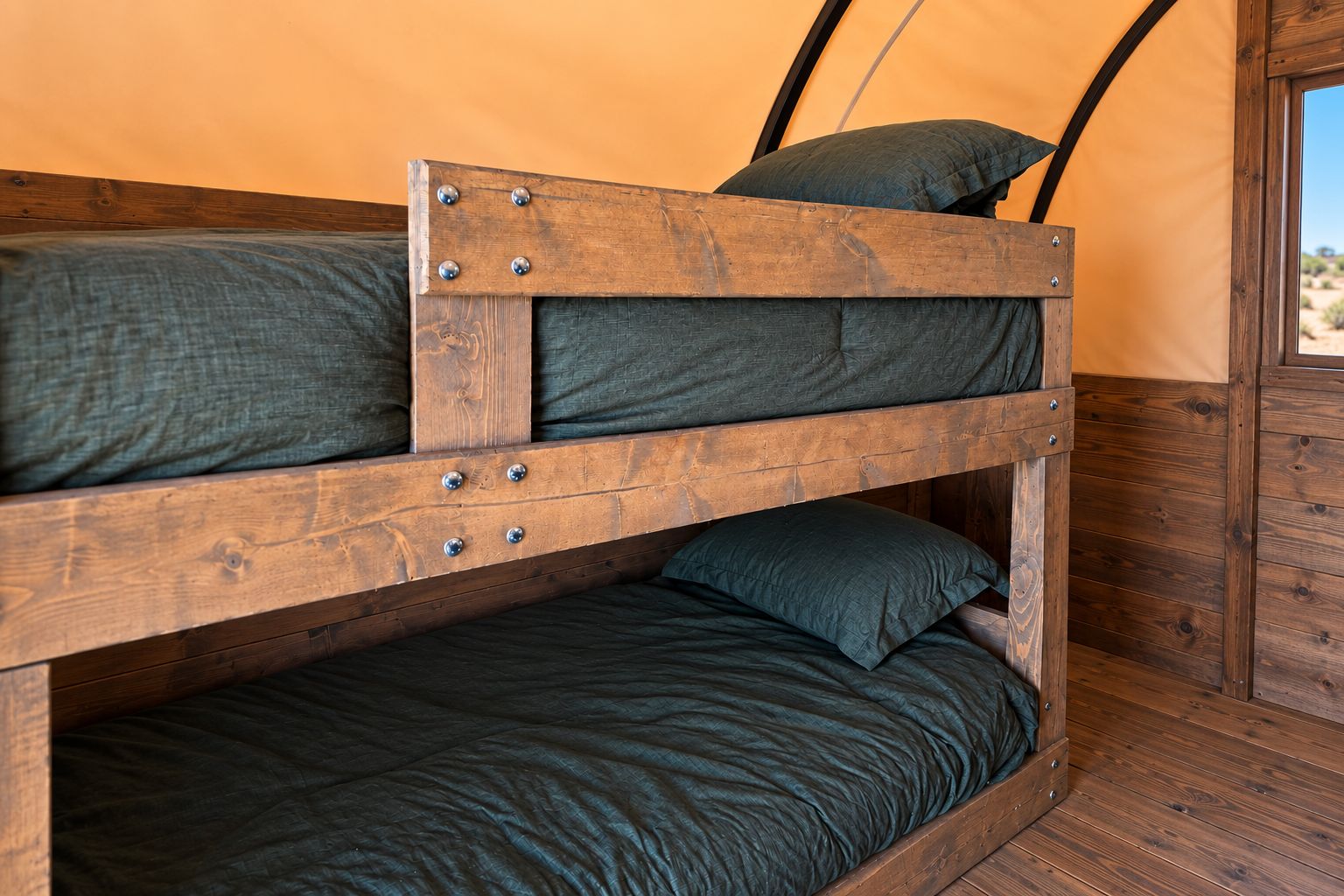 A bunk bed with metal fixtures and a view of the outdoors through a window.