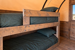 A bunk bed with metal fixtures and a view of the outdoors through a window. - High Chaparral RV & MHC (Casa Grande)