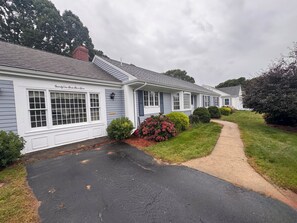 A row of white buildings with a paved driveway and well-maintained lawns. - Beach Days, Family Nights, and Cape Cod Memories! (Yarmouth)
