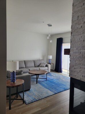 Ein modernes Wohnzimmer mit einer Couch, zwei Couchtischen und einer Lampe.