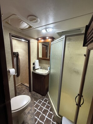 Ein kleines Badezimmer mit Toilette, Waschbecken und Duschbereich.