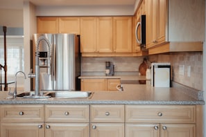 A modern kitchen with wooden cabinets, stainless steel appliances, and a granite countertop. - Creekside Peaceful retreat Near Chicopee, 401 & YKF airport (Kitchener)