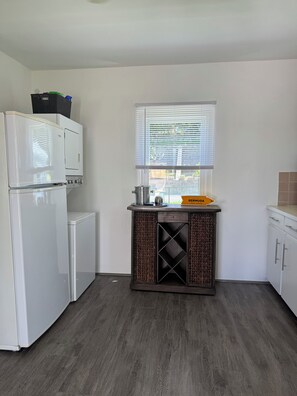 A kitchen with a refrigerator, a sink, and a window with blinds. - Fabulous large studio cottage with AC in charming Smiths (Smiths)