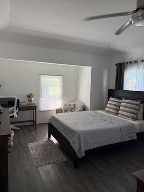 A bedroom with a bed, desk, chair, and a ceiling fan. - Fabulous large studio cottage with AC in charming Smiths (Smiths)