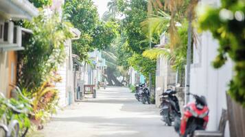 Una calle estrecha bordeada de motocicletas y bicicletas estacionadas, con edificios que muestran balcones y ventanas.