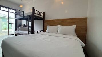 A bunk bed room with a wooden headboard, white bedding, and a view of the outside.
