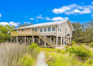 A two-story house with a wooden deck and a staircase leading to the upper level. - Bay-view 5BR Gulf Shores Home, Sleeps 12, and Easy Beach Access (Gulf Shores)