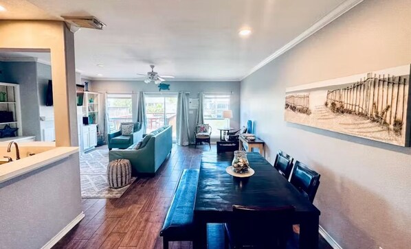 A spacious living area with a dining table, sofas, and a kitchen area. - Spacious 3-bedroom waterfront condo on the island. (Corpus Christi)