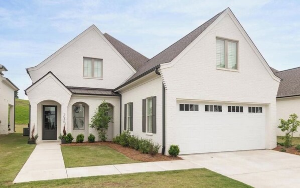 A two-story house with a garage, a front entrance, and a small front yard. - Spacious 4-bedroom house on the Country Club. Less than 2mi from the stadium! (Oxford)