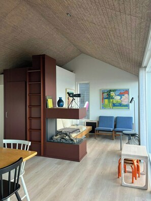 Un espace de vie compact comprenant un lit superposé, un bureau et un coin salon.