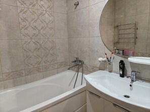 Une salle de bain avec une baignoire, un lavabo et un miroir.