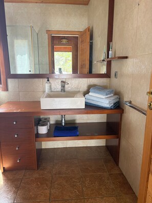 A bathroom with a wooden vanity, a sink, a mirror, and a towel rack. - Casa Bolets - A house in the woods near the best beaches in southern Catalonia (L'Ametlla de Mar)