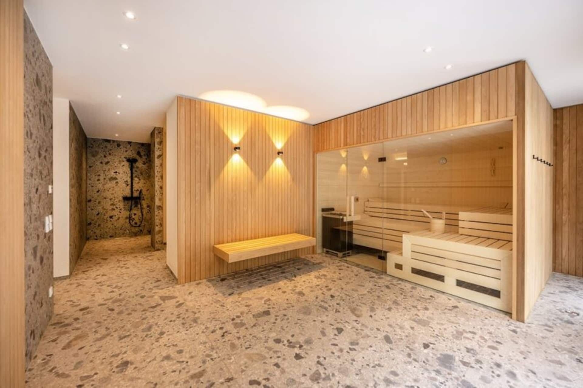 Un sauna avec des bancs et un sol en pierre.