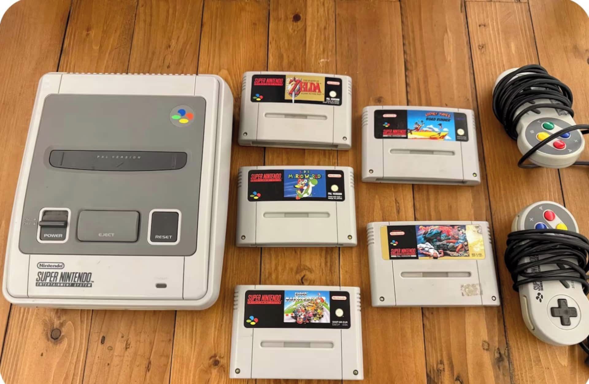 Una consola Super Nintendo Entertainment System con varios cartuchos sobre una superficie de madera.
