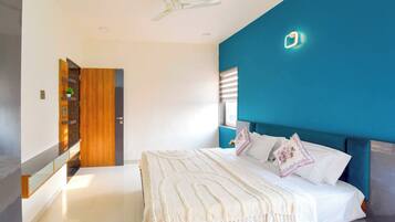 Un dormitorio con una cama, ventilador de techo, mesita de noche y una lámpara de pared.
