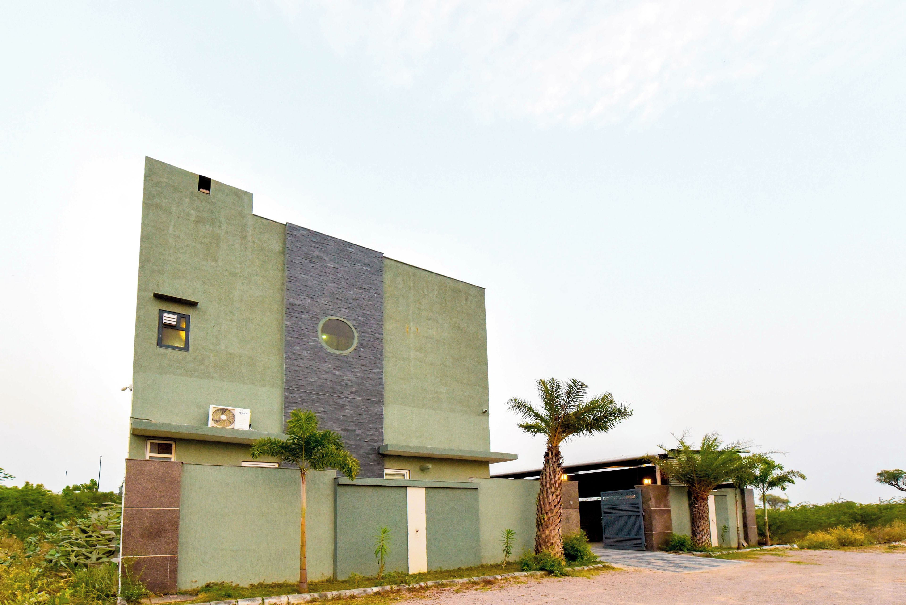 A modern building with a flat roof, a large window, and a door.
