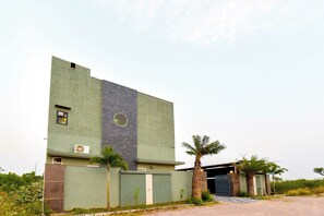 A modern building with a flat roof, a large window, and a door.