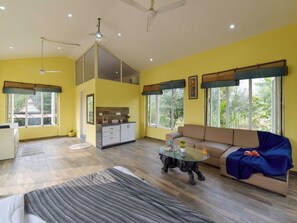 A spacious living area with a sofa, a coffee table, and a dining area with a kitchen counter.