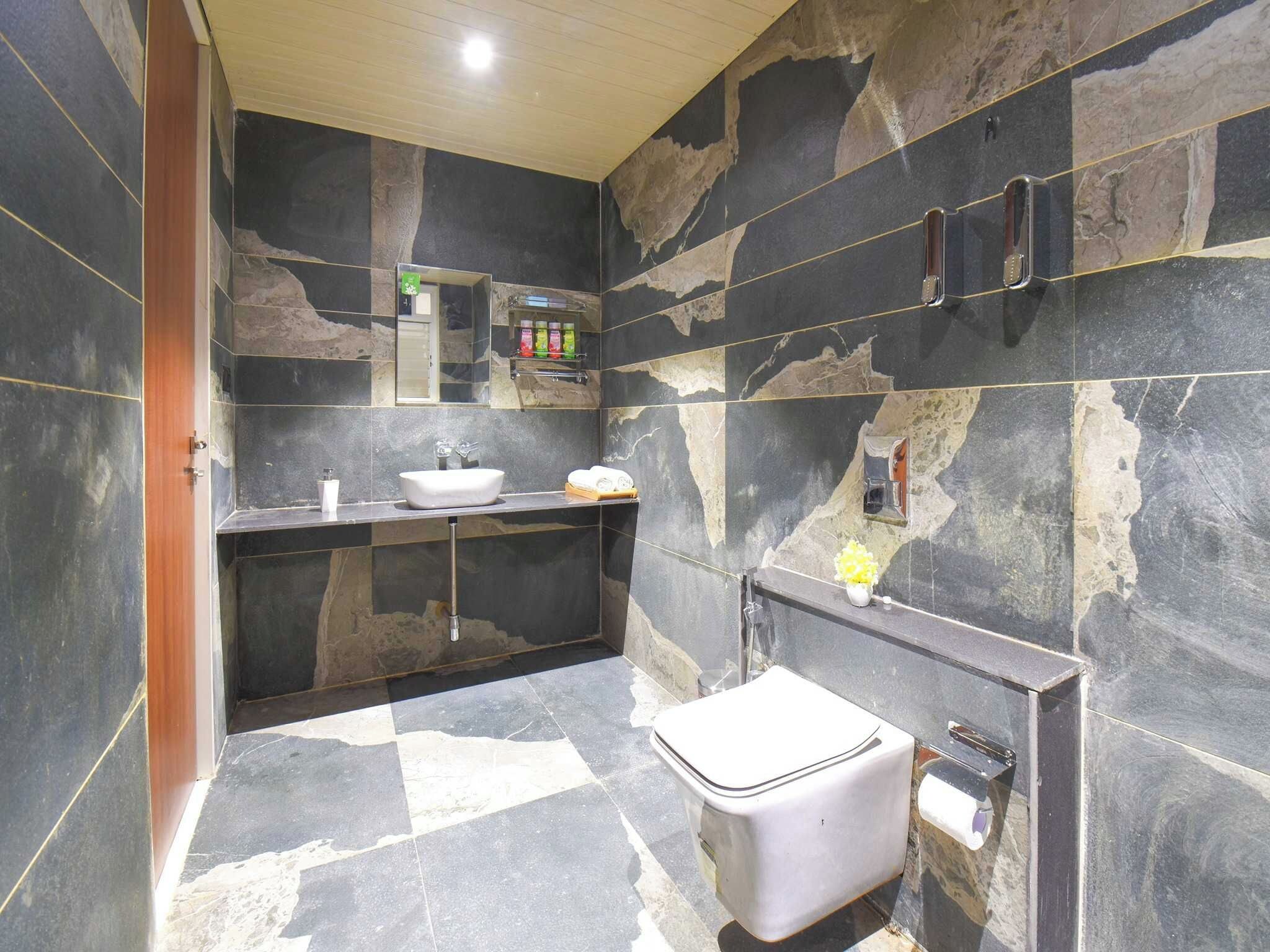 A bathroom with a sink, mirror, and toilet.