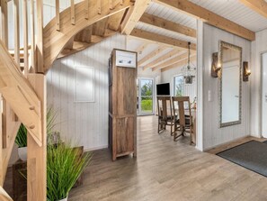 A wooden staircase leading to a room with a television, wooden chairs, and a large mirror. - NEW - Beach Lodge (Kappeln)