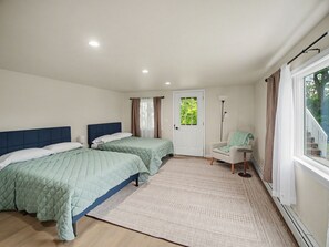 A room with two beds, a chair, a door, and a window. - Point Gratiot Lake House, Sleeps 12+, Lake Views (Dunkirk)