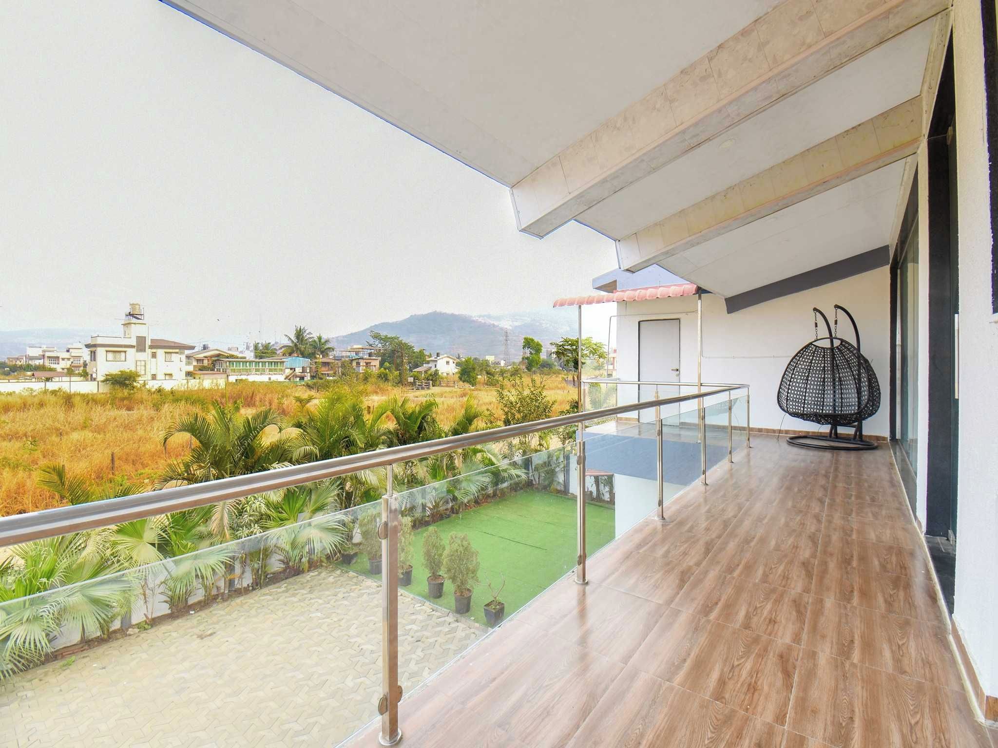 Un balcón con vista a una zona residencial y una montaña al fondo.