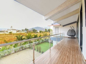 Un balcon donnant sur un quartier résidentiel et sur une montagne au loin.