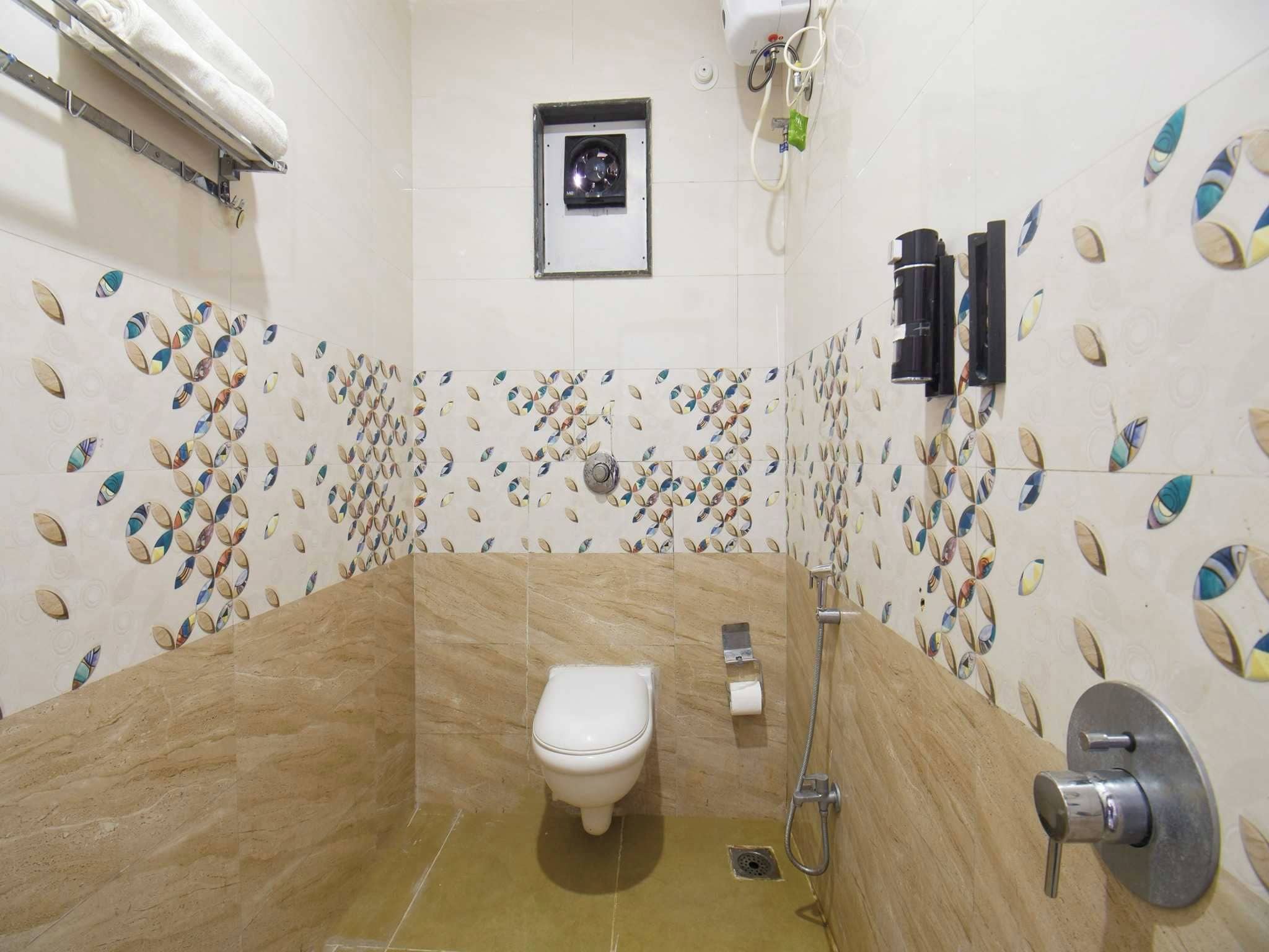 Un baño con inodoro, ducha y lavamanos empotrado.