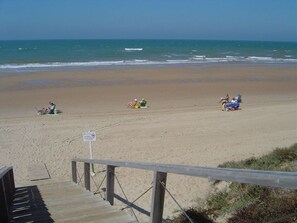 A beach with a wooden walkway leading to the shore. - ** 2027 Eclipse Special - Costaballena ** (AN)
