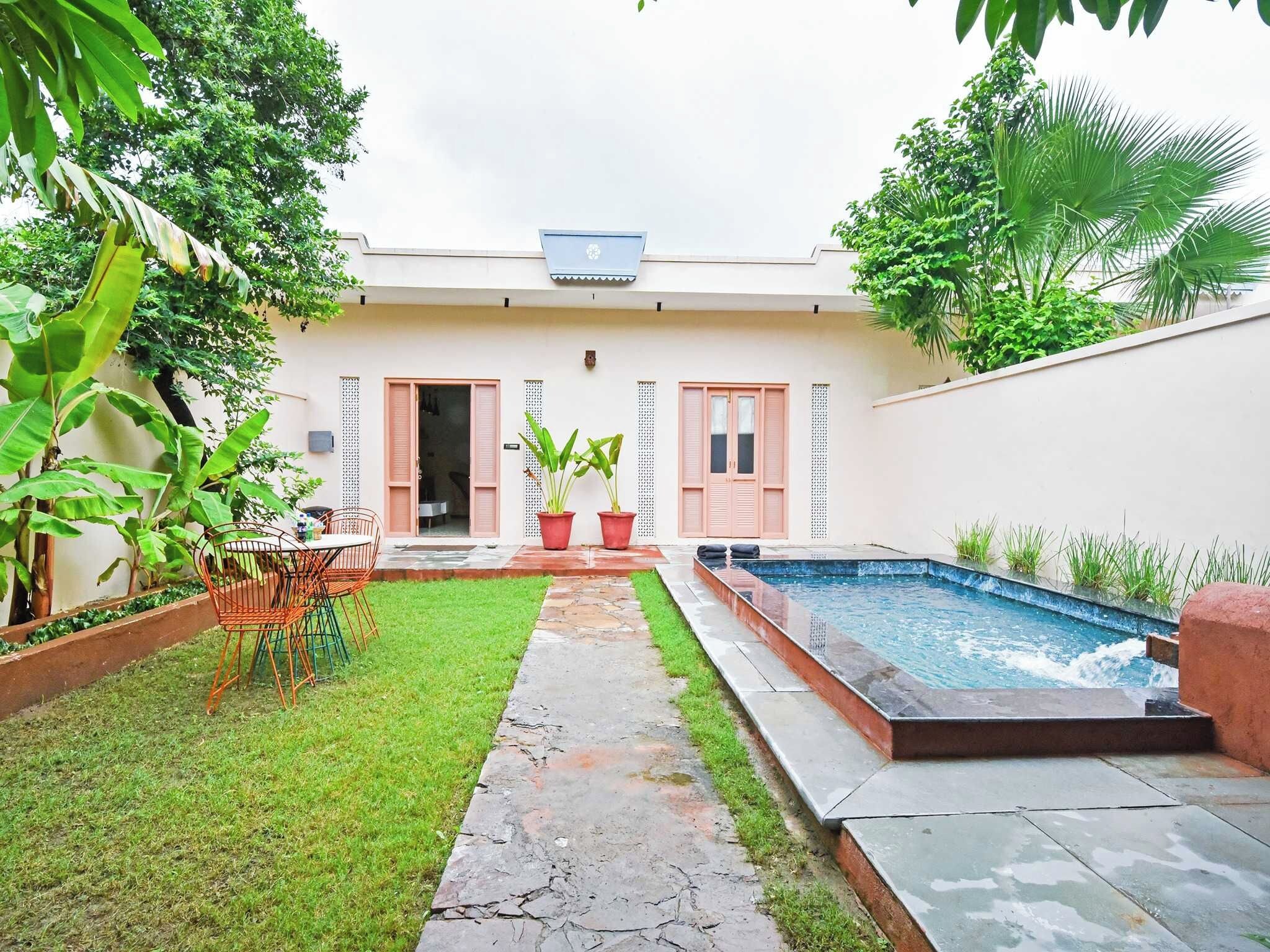 Una propiedad residencial con piscina, un sendero pavimentado y un pequeño jardín.