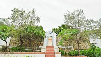 Un muro de piedra con una escalera que lleva a una puerta blanca.