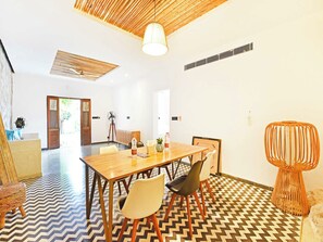 Un comedor con una mesa de madera, sillas y un suelo estampado.