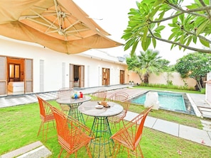A private outdoor area with a pool, a dining table with chairs, and a covered seating area. - DanCenter Parijat Villas & Suites Pool (Udaipur)