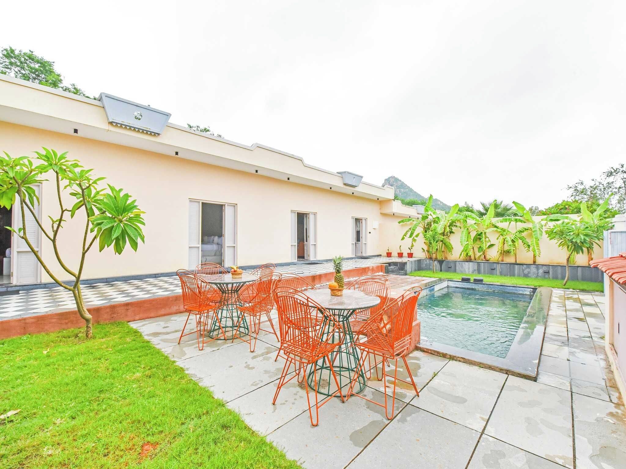 Una propiedad residencial con piscina, zona de estar al aire libre y un pequeño jardín.