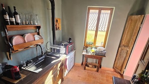 Una cocina con encimera de madera, un lavabo, una estufa y una ventana con vistas al exterior.