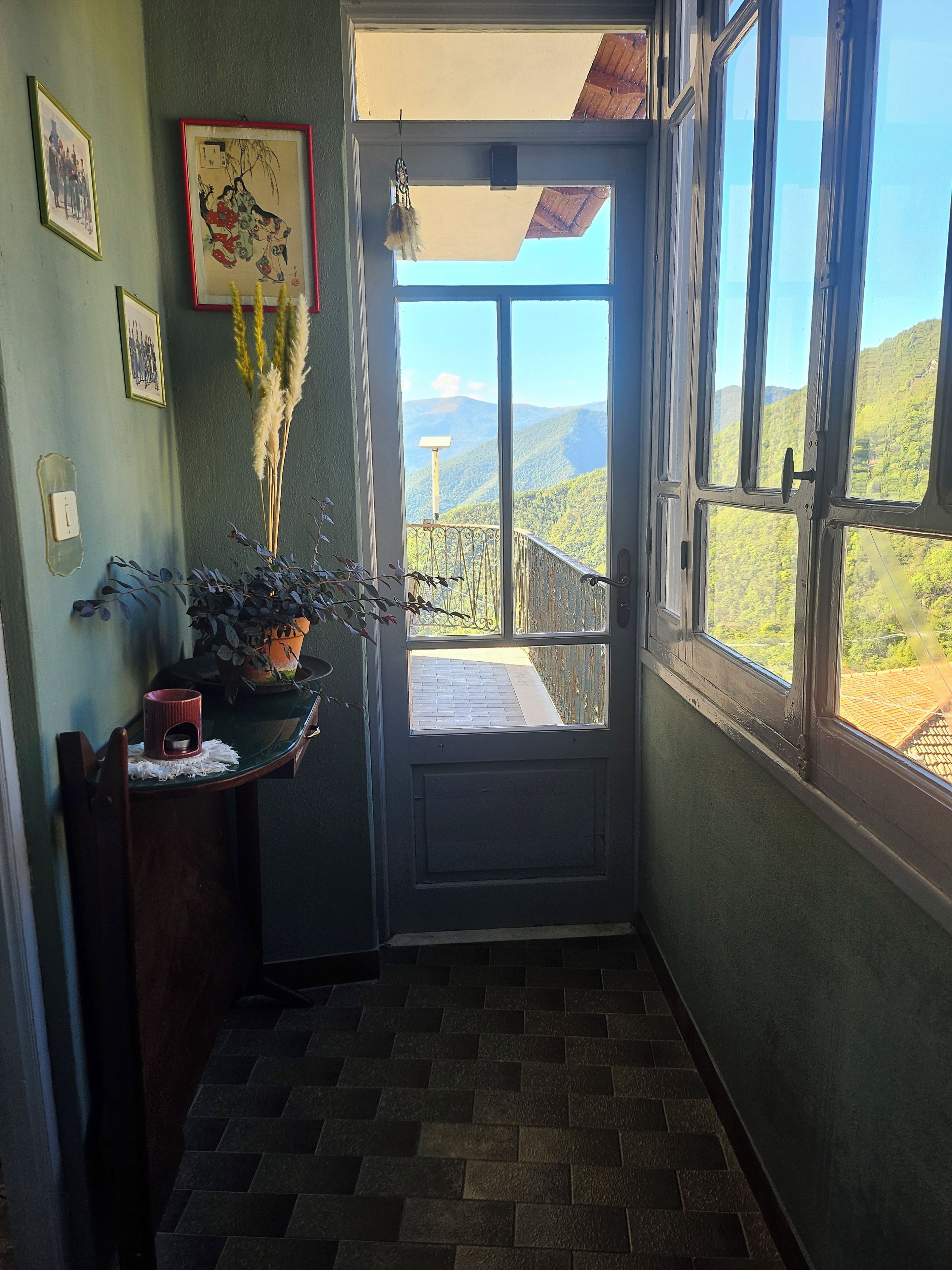 A room with a view of a mountainous landscape through a large window.