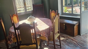 Un comedor con una mesa preparada para cuatro personas, un banco y vistas al exterior a través de amplios ventanales.