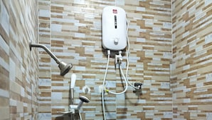 A shower area with a handheld showerhead, a wall-mounted control unit, and a handheld faucet. - Résidence Nivada Suite (Porto-Novo)