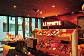 Eine Speisenauslage mit verschiedenen verpackten Snacks und einem Schild mit der Aufschrift 'LARRYETTE'.