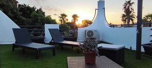 A rooftop terrace with lounge chairs, a potted plant, and an air conditioning unit. - House for 4–6 people in Torrevieja (Torrevieja)