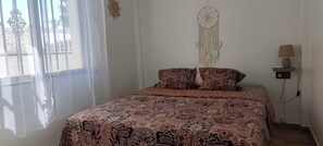 A bedroom with a bed, a nightstand, a lamp, and a wall decoration. - House for 4–6 people in Torrevieja (Torrevieja)