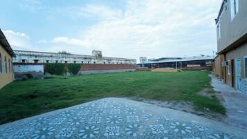A courtyard with a patterned pavement, a brick wall, and a building with a flat roof.