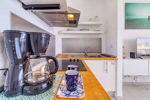 A compact kitchenette with a coffee maker, a kettle, a sink, and a small countertop. - Apartamento Delphin Sol – Sea Views and Beachfront Location in Puerto Naos (Puerto de Naos)
